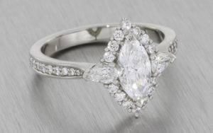 Platinum marquise ring with a round brilliant and pear shape diamod halo