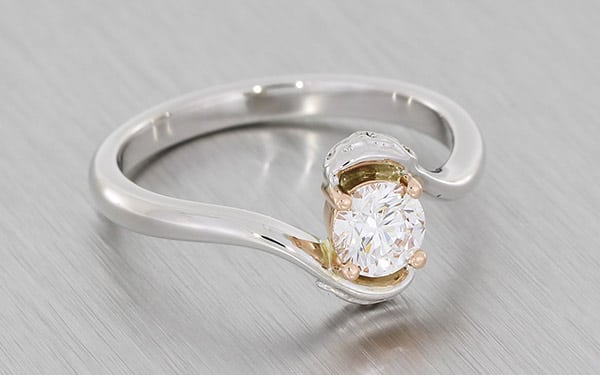 Round brilliant diamond set in a bypass shank with intricate Celtic knot detailing